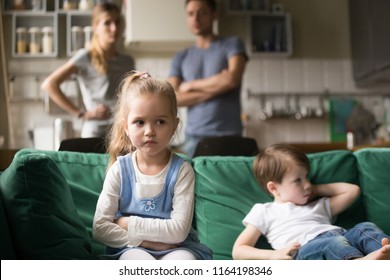 Frustrated kid girl feels upset, offended or bored ignoring avoiding worried parents and brother, little sad sister not talking to child boy after fight sulking sitting on couch, siblings rivalry - Powered by Shutterstock