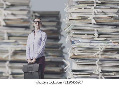 Frustrated Lost Businesswoman Staring At Huge Piles Of Paperwork, Work Overload And Bureaucracy Concept