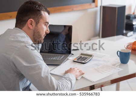 Frustrated man calculating bills and tax  expense