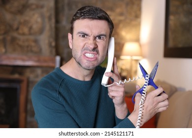 Frustrated Man Cutting Landline Telephone Cord