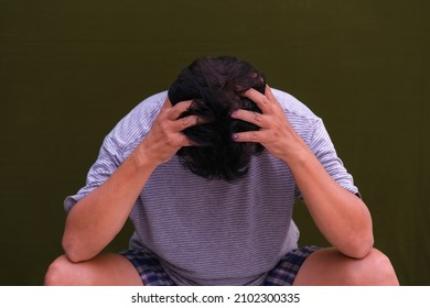 Frustrated Man Squatting With Head Facing Down