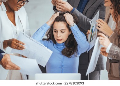 Frustrated millennial female worker sitting at table with colleagues, felling tired of working quarreling at business meeting. Upset stressed young businesswoman suffering from head ache at office. - Shutterstock ID 2278103093