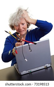 Frustrated Old Woman With Laptop And Many Different Computer Cables