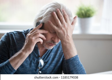 Frustrated Older Mature Retired Man Feeling Upset Desperate Talking On The Phone Having Problems Debt, Stressed Sad Middle Aged Male Depressed By Hearing Bad News During Mobile Conversation At Home