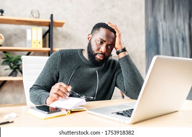 Frustrated Sad Black Guy Is Watching At Laptop Screen And Holding Head With His Hand. He Read Bad News