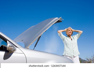 Frustrated Senior Woman At Car Breakdown With Open Hood