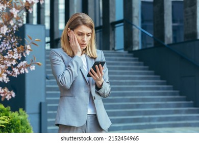 Frustrated And Shocked Business Woman Reading Bad News Online From Phone, Businesswoman Outside Office In Business Suit