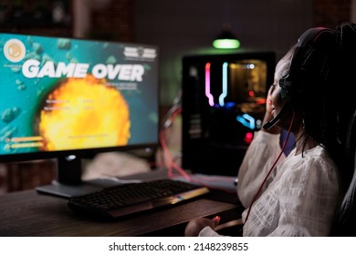 Frustrated streamer losing action video games competition play, using pc to stream gaming tournament. Female gamer feeling sad about lost online rpg multiplayer gameplay championship.