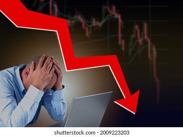 Frustrated Stressed Failed Business Man Sitting With Laptop With Financial Market Chart Graphic Going Down. Poor Economy Concept. Face Expression, Emotion  Reaction On A Bad Day.

