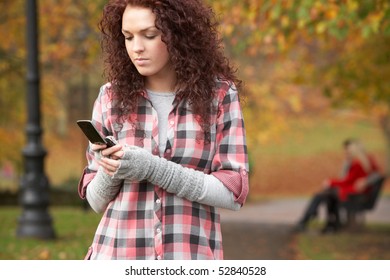 Frustrated Teenage Girl Making Mobile Phone Call In Autumn Landscape