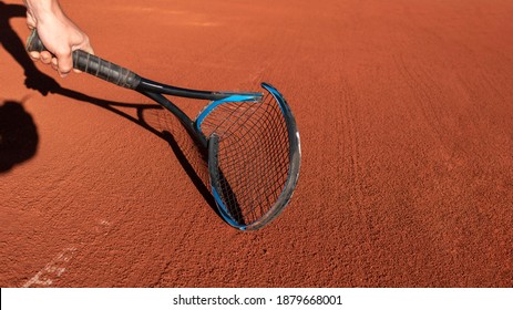 Frustrated Tennis Player Broke His Racket In Fit Of Anger. Broken Tennis Racket On Clay Tennis Court. Mental Health In Sports. Negative Emotions, Stress, Dissatisfaction, Defeat, Crash, Failure, Loss