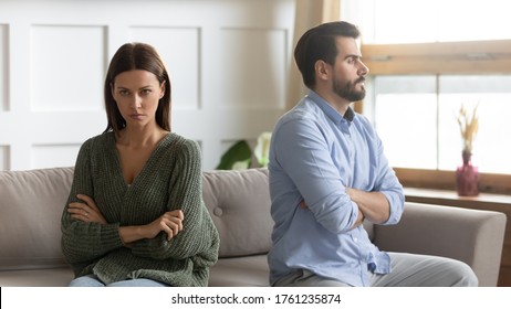 Frustrated thoughtful girlfriend thinking about relationship problems, ignoring boyfriend after quarrel, angry man and woman not talking, sitting separately on couch, family crisis conflict concept