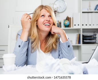 Frustrated tired businesswoman sitting at workplace among crumpled papers - Shutterstock ID 1471635578