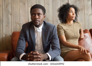 Frustrated Upset African Couple In Quarrel Sitting On Sofa Not Talking After Fight, Stubborn Disappointed Black Man Ignoring Sad Depressed Offended Woman, Problem In Marriage Relationships Concept