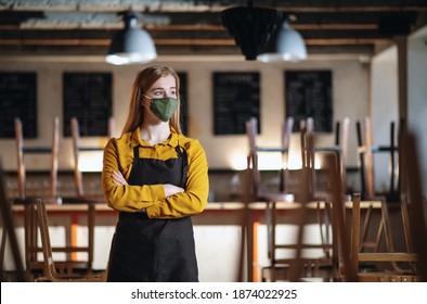 Frustrated waiter standing in closed cafe, small business lockdown due to coronavirus. - Shutterstock ID 1874022925
