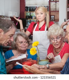 Frustrated Waitress With Customers Trying To Read The Menu