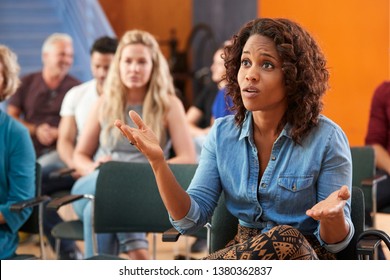 Frustrated Woman Asking Question At Group Neighborhood Meeting In Community Center