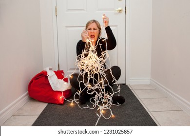  A frustrated woman can't get the christmas lights to untangle so she screams in anger