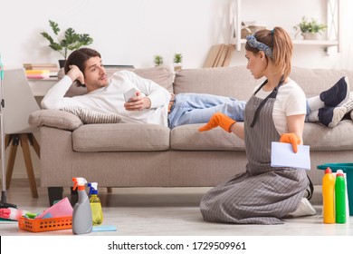 Frustrated Woman Cleaning Flat And Arguing With Her Lazy Husband Lying On Couch, Not Sharing Household Chores - Shutterstock ID 1729509961