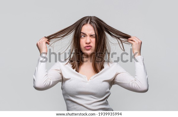 Frustrated woman\
having a bad hair. Woman having a bad hair, her hair is messy and\
tangled. Messy hair. Brunette woman with messed hairs. Girl having\
a bad hairs. Bad hairs\
day.
