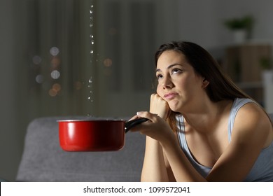 Frustrated woman looking at home water leaks sitting on a couch in the living room at home