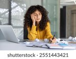 Frustrated woman at office desk, laptop open, surrounded by crumpled papers. Represents work stress, creativity block during busy day. Concept of workplace pressure and fatigue.