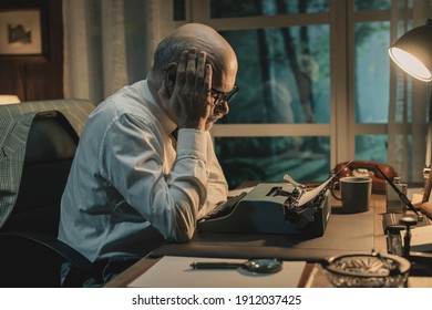 Frustrated Writer Experiencing A Creative Slowdown, He Is Sitting At Desk And Typing On A Vintage Typewriter