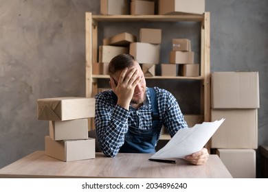 Frustrated frustrated young business owner reading bad news in a mail letter, paper document, depressed tense guy worried about high tax bill, bad debt notice, money problem. Copy space.