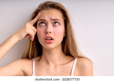 Frustrated young female feeling stressed upset about facial skin problem concept wrinkles or pimple, worried depressed lady touch skin on forehead annoyed by acne, close-up portrait. copy space