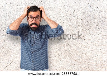 frustrated Young hipster man over textured background 