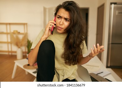 Frustrated Young Hispanic Woman Being Angry Because Of Spam Unwanted Robocall. Dissatisfied Annoyed Female Customer Complaining About Internet Service On Mobile Phone, Expressing Indignation