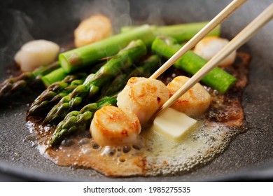 Fry asparagus and scallops in butter in a frying pan