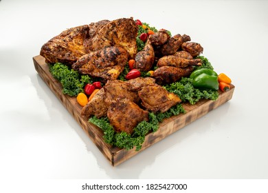 Fryer Drumsticks, Thighs And Split Breasts On A Wood Cutting Board, Isolated On White Background.