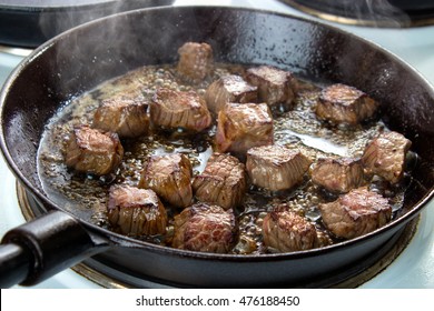 Frying Beef Bottom Round Roast Cubes In Cast Iron Skillet , Meat Flipped Once