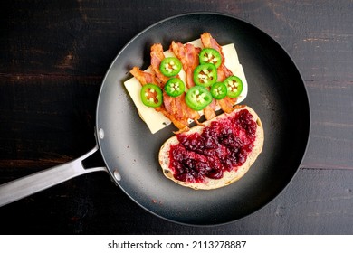 Frying A Blackberry Bacon Grilled Cheese Sandwich In A Skillet: Two Halves Of A Grilled Cheese Sandwich With Bacon In A Nonstick Frying Pan