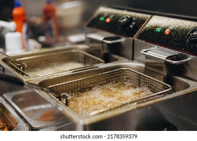 Frying chicken nuggets in deep fryer. Restaurant meal preparation - Shutterstock ID 2178359379