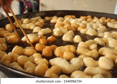 Frying Deep Fried Dough Sticks In Pan Of Hot Cooking Oil. Chef Cooking And Prepare White Raw Flour On Table Beside. The Street Food In Thailand. Chinese And Thai Style. Asian Food Concept.Select Focus