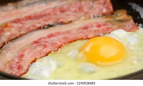 Frying Fried Eggs With Bacon In Hot Pan. Family Breakfast Concept