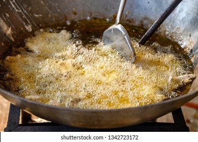 Frying the fried taro with flipper on boiling oil in big pan - Shutterstock ID 1342723172