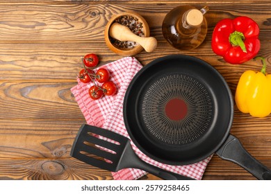 Frying pan. Empty non-stick frying pan and kitchen utensils set on textured wooden background. cooking concept. Top view. Space for text. Flat lay. Recipe.