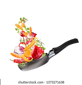 Frying pan with flying vegetables, isolated on white backfground – image - Shutterstock ID 1373271638