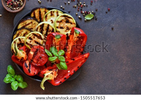Frying pan with grilled vegetables on a stone background. View from above. Picnic. Barbecue.