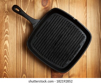 Frying Pan On Wooden Table Background. View From Above