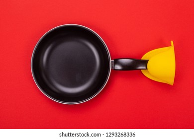 Frying Pan With Oven MITT Isolated On Red Background