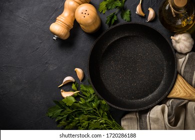 Frying pan or skillet with ingredients for cooking on black slate background. Top view with copy space. Food cooking concept, food cooking background.