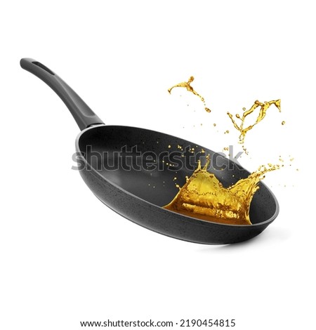 Frying pan and splashing cooking oil on white background