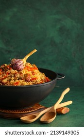 Frying Pan With Tasty Asian Pilaf On Color Background