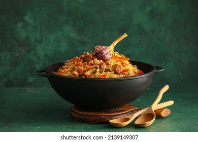 Frying Pan With Tasty Asian Pilaf On Color Background