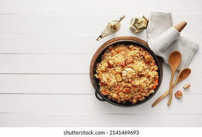 Frying Pan Of Tasty Asian Pilaf On White Wooden Background