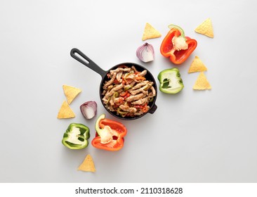 Frying Pan With Tasty Beef Fajita, Nachos And Vegetables On White Background